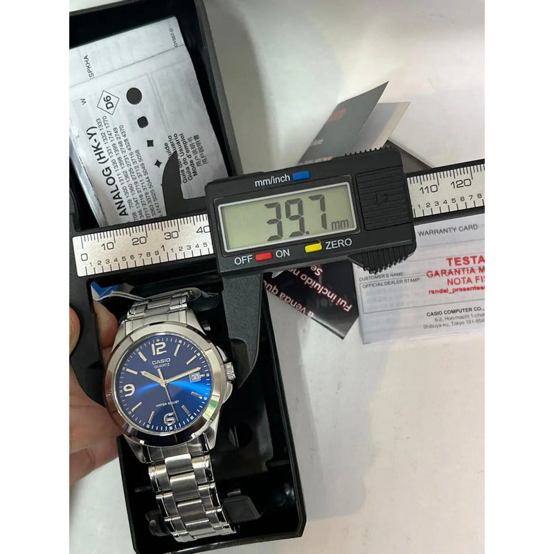 Reloj Pulsera Casio Mtp-1215 Con Correa De Acero Inoxidable Color Plateado - Fondo Azul