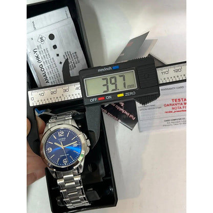 Reloj Pulsera Casio Mtp-1215 Con Correa De Acero Inoxidable Color Plateado - Fondo Azul