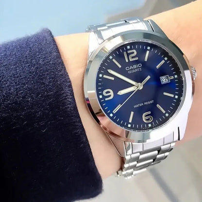 Reloj Pulsera Casio Mtp-1215 Con Correa De Acero Inoxidable Color Plateado - Fondo Azul
